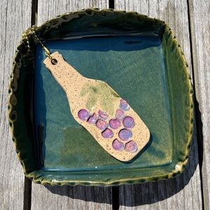 GLAZED CERAMIC NAPKIN HOLDER W/ CERAMIC WINE BOTTLE WEIGHT. NEW.